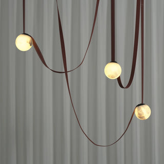 Anouk Draped Strap Alabaster Chandelier Vidirlighting Close-Up View of Three Illuminated Natural Alabaster Spheres Highlighting Mineral Veins and Draped Straps