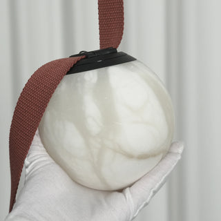 Anouk Draped Strap Alabaster Chandelier Vidirlighting Artisan Hand in White Glove Holding Polished Translucent White Alabaster Globe Revealing Unique Mineral Veins