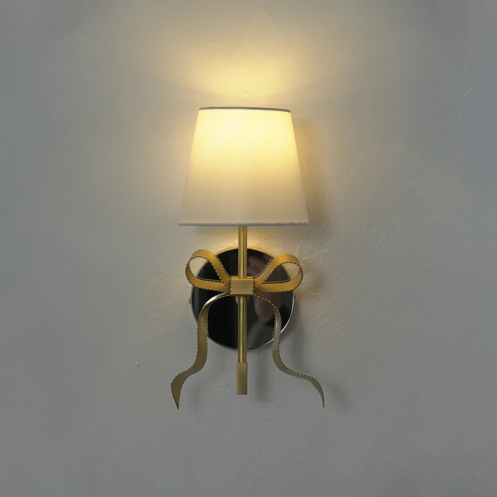 The same gold ribbon bow sconce switched on