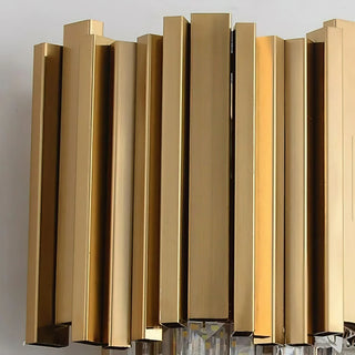 A close-up shot of the gold-tone stainless steel tubing at the top of the wall lamp, showcasing the material and lustrous texture of multiple gold-plated square tubes arranged in a staggered, varying-height configuration.