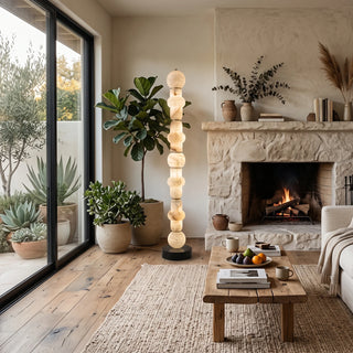 Cairn Alabaster Stacked Floor Lamp Vidirlighting Standing next to Floor-to-Ceiling Wooden Bookcase and Cream Fabric Sofa for Evening Reading