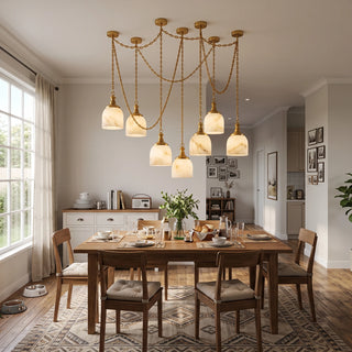 Carillon Chain Alabaster Bell Chandelier Vidirlighting Brushed Brass Multi-Light Draped Chain Chandelier Suspended over Long Wooden Dining Table in Sunlit Room