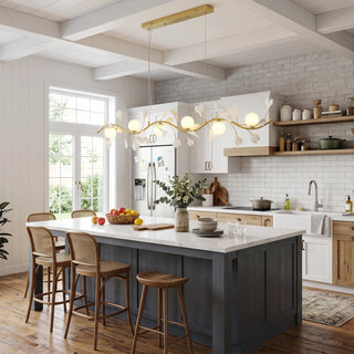 Ginkgo Vine linear branch chandelier illuminated over a blue kitchen island with rattan stools by Vidir Lighting