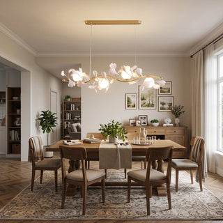 Warm illuminated Ginkgo Vine linear chandelier in a cozy dining room with wooden credenza by Vidir Lighting