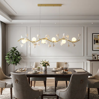 Ginkgo Vine linear branch chandelier above a luxury dining table with grey upholstered chairs by Vidir Lighting