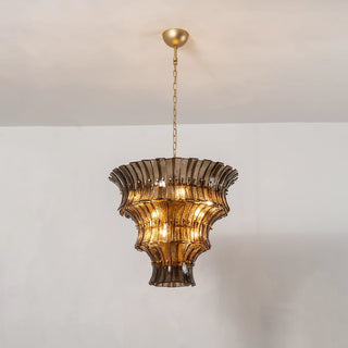 Lido amber smoke tiered textured glass chandelier warm illuminated on white wall by Vidir Lighting