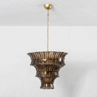 Lido amber smoke tiered textured glass chandelier warm illuminated on white wall by Vidir Lighting