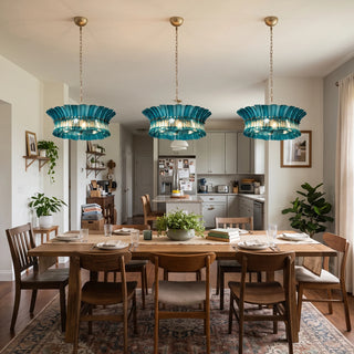 Trio of Lido blue textured glass chandeliers arranged above a long dining table by Vidir Lighting