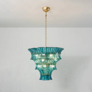 Lido teal blue tiered glass chandelier hanging above showroom dining set by Vidir Lighting