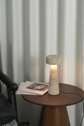 Travertine Kiwa Conical Table Lamp Vidirlighting Placed on Soft Textured Fabric Surface Showing Black Power Cable with Convenient Inline Button Switch